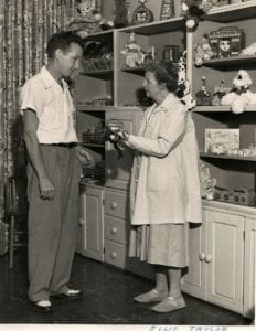 volunteer showing toy to shopper in Cincinnati Children's Gift Shop, 1958